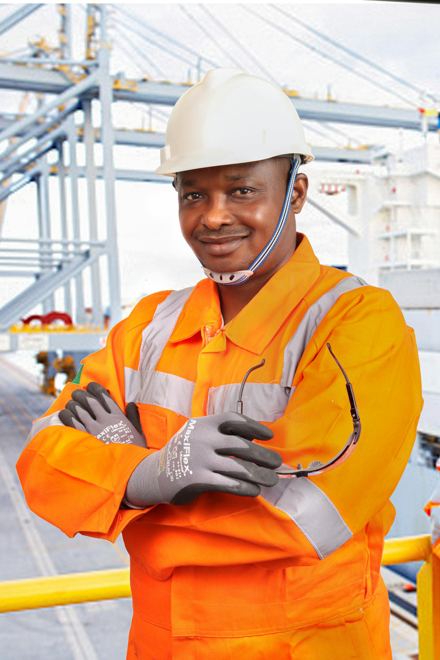 Confident construction worker in safety gear on an industrial site.