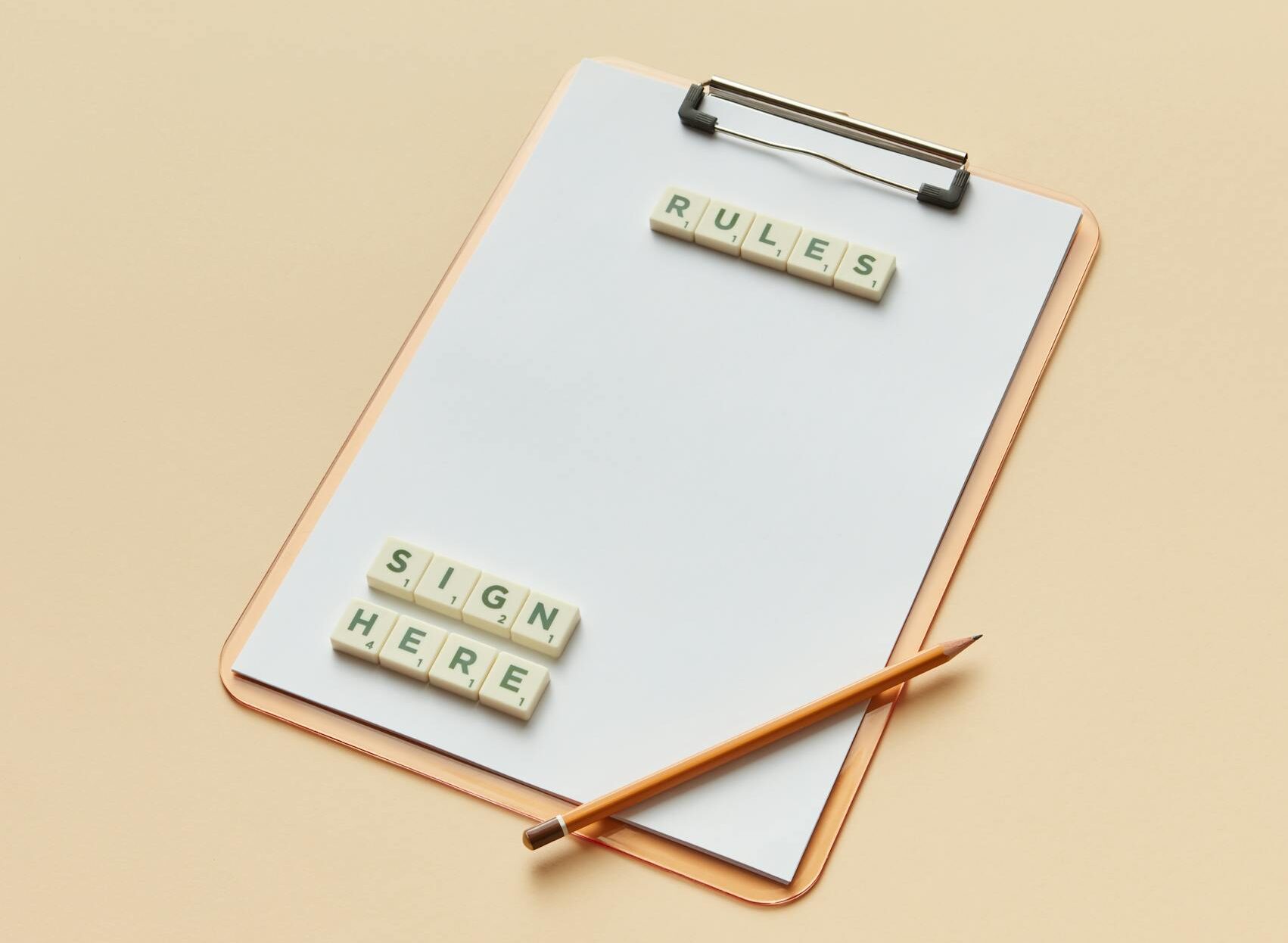 Minimalist image of a clipboard with letter tiles spelling 'rules' and 'sign here', alongside a pencil.